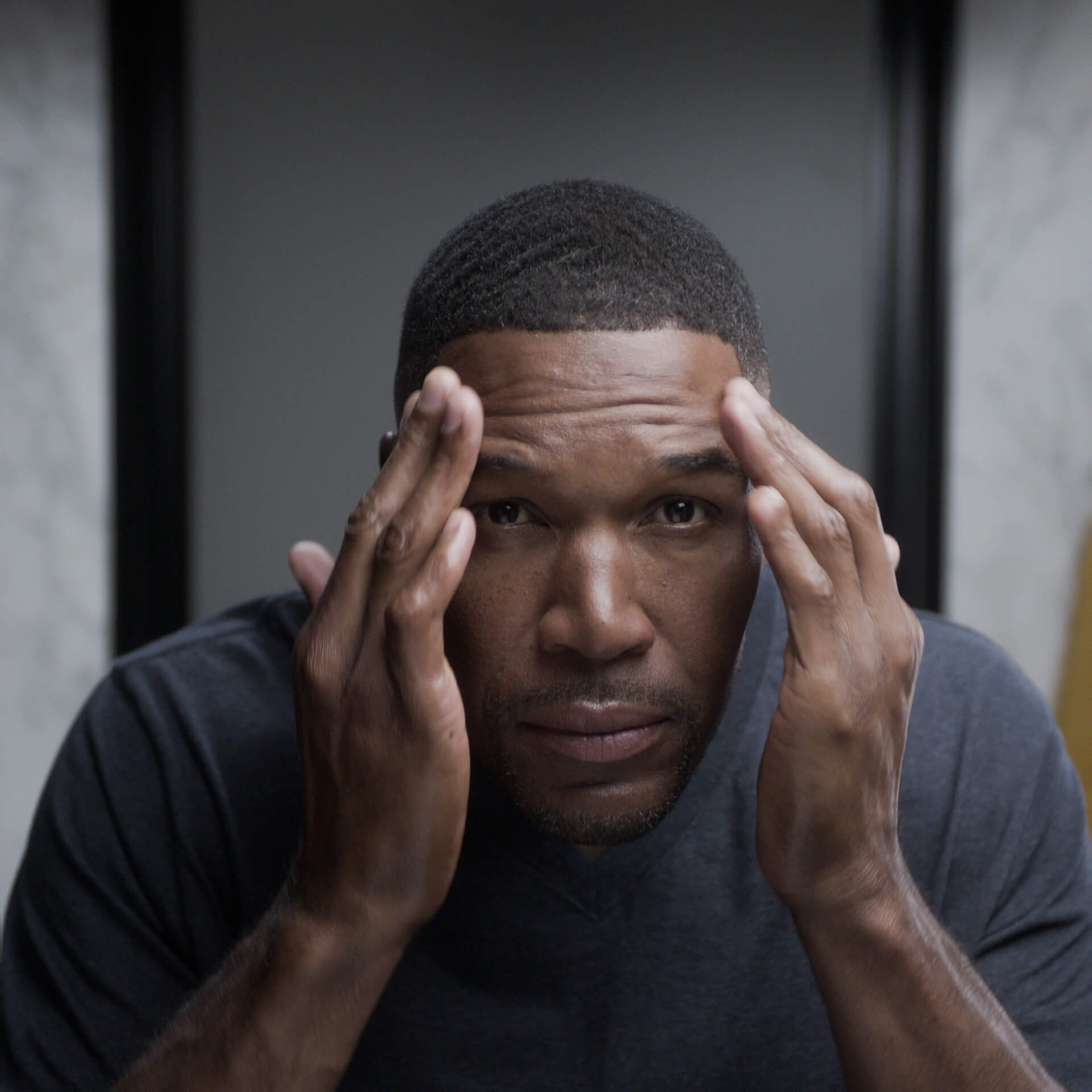Michael Strahan touching his face